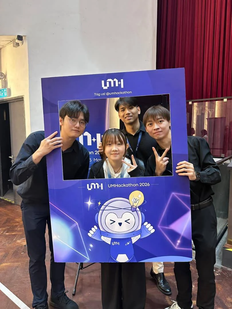 Four members of DayDreaming Lab holding an UMHackathon 2026 event frame.